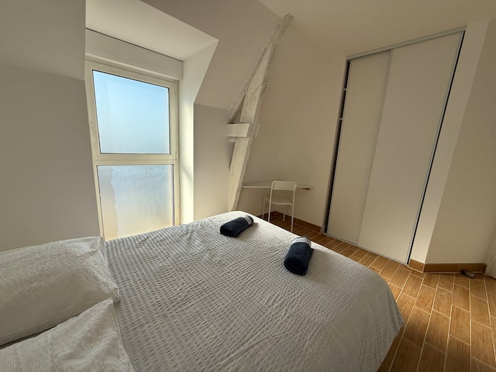 Chambre double mansardée avec placard coulissant et fenêtre lumineuse dans le gîte Austral Saint-Malo